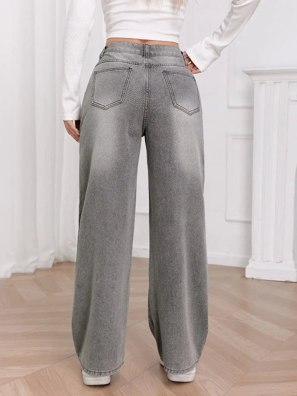 Person wearing gray wide-leg jeans in a minimalistic room.