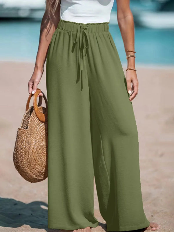 Person wearing green wide-leg pants on a beach