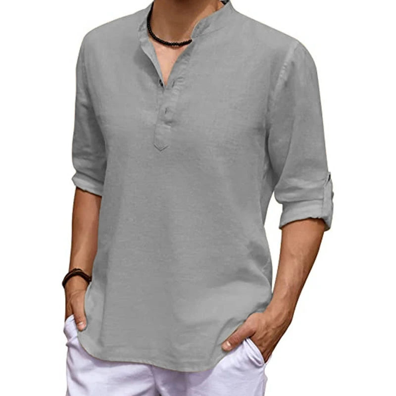 Person wearing a gray long-sleeve shirt with rolled-up sleeves on a white background