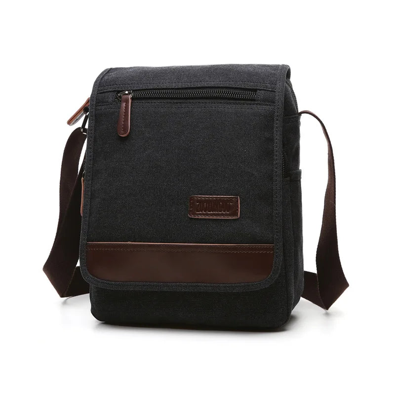 Black canvas crossbody bag with brown leather accents on a white background