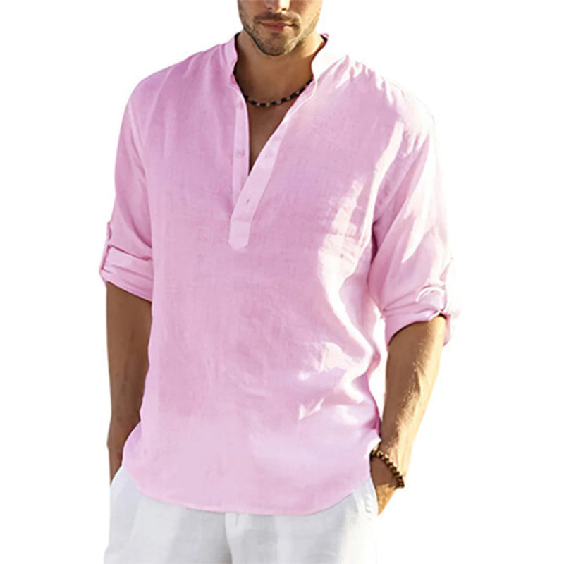 Man wearing a light pink shirt with rolled-up sleeves on a white background