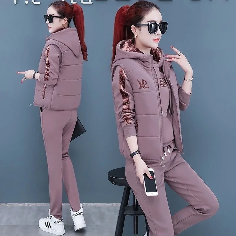 Woman modeling a tracksuit with a brand logo against a gray background