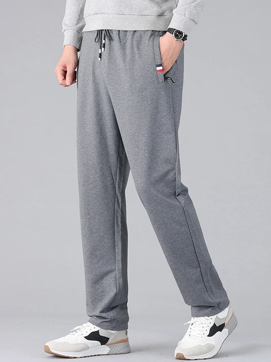 Person wearing gray sweatpants on a plain background