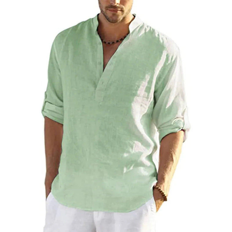 Man wearing a light green shirt with rolled-up sleeves on a white background