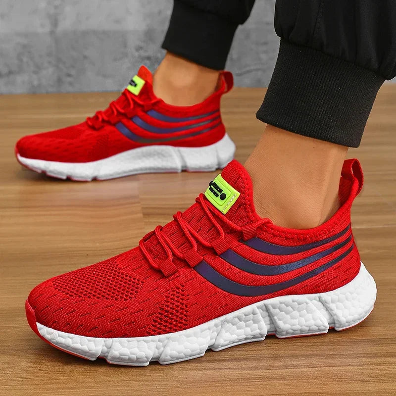 Red running shoes with white soles worn by a person on a wooden floor.