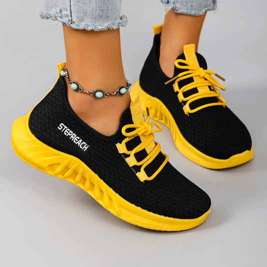 Black and yellow sneakers with 'Stepreach' branding on a gray background