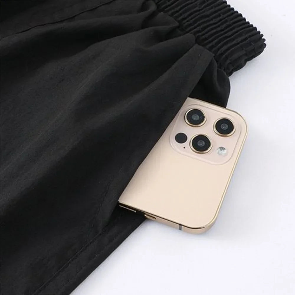 Gold phone case on a white background and black shorts