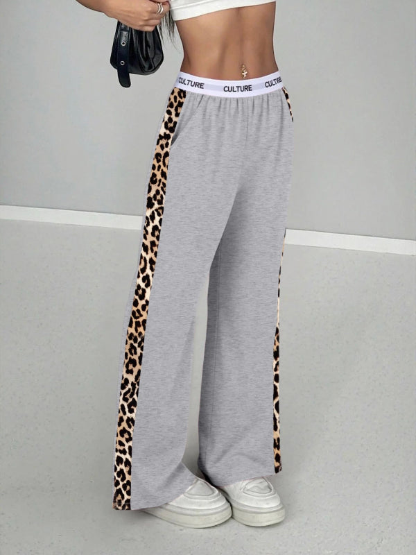 Gray sweatpants with leopard print side panels worn by a person on a gray background