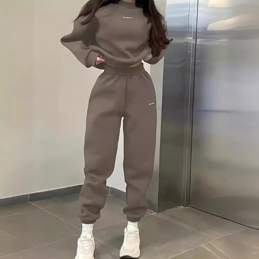 Person wearing a brown tracksuit standing in front of a metallic elevator.