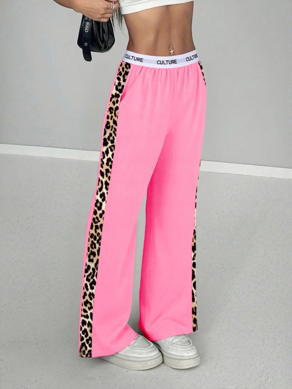 Pink pants with leopard print side panels worn by a person on a gray background