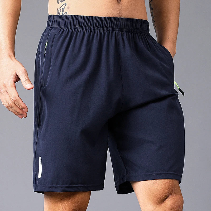 Navy blue athletic shorts worn by a person on a gray background