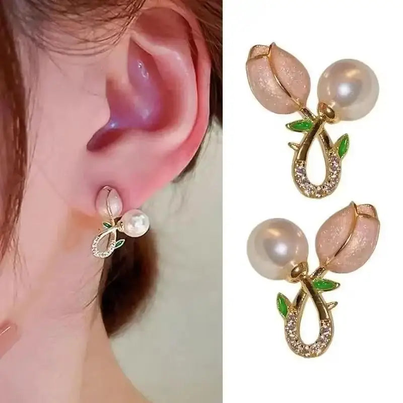 Pearl earrings with gold leaves worn on an ear, shown from multiple angles.