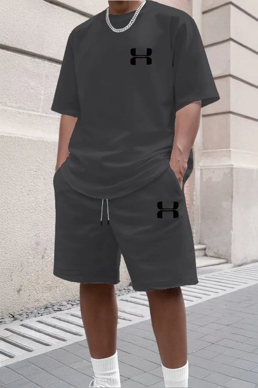 Person wearing a black Under Armour outfit standing against a stone wall.