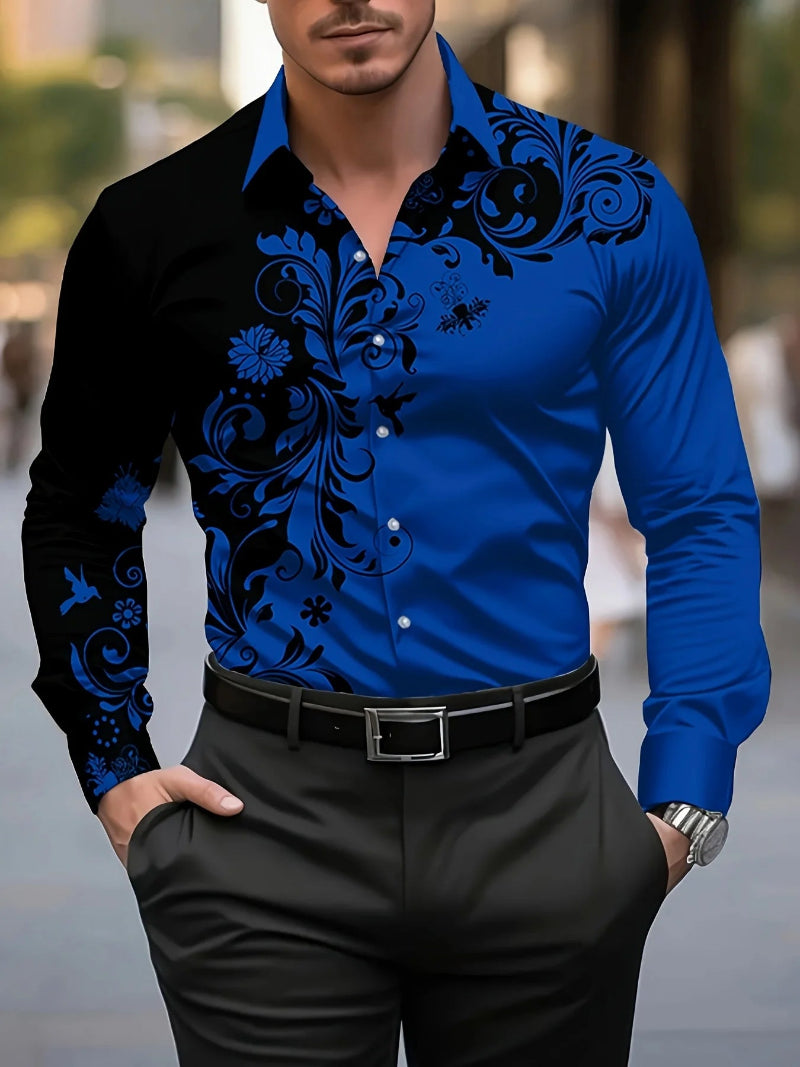 Man wearing a blue shirt with black floral patterns and black pants outdoors.