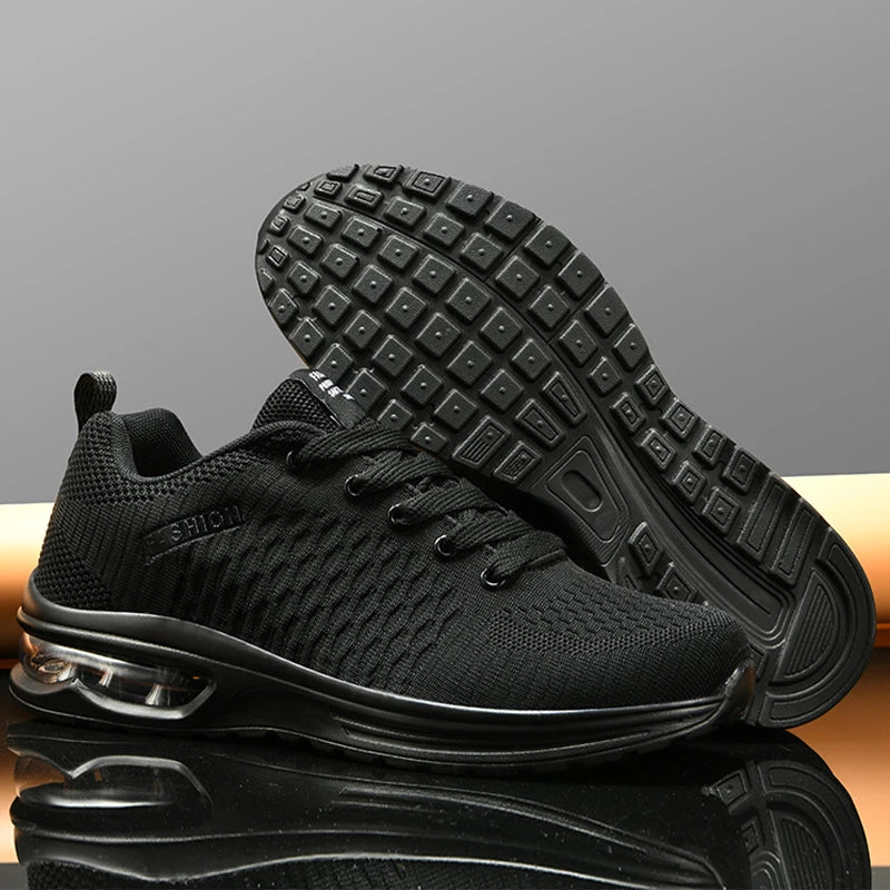 Black athletic shoes with air cushion sole on a reflective surface with a gray background