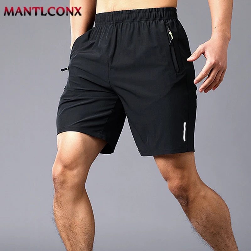 Black athletic shorts worn by a person on a gray background, with 'MANTLCONX' branding.