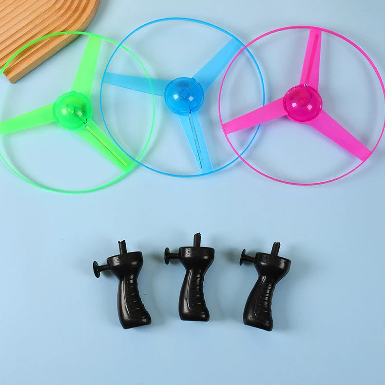 Three colorful spinning tops with black handles on a light blue background