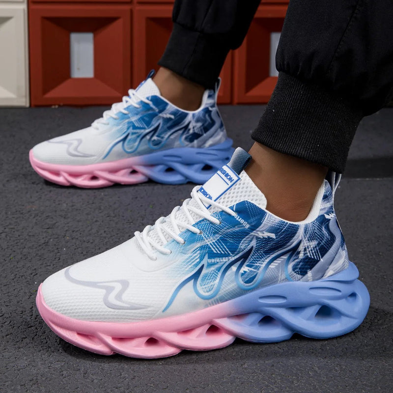 White sneakers with blue and pink soles worn by a person on a dark surface.