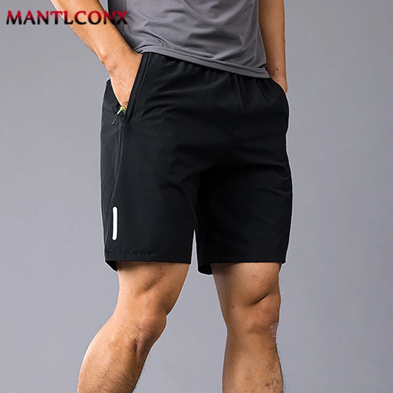Person wearing black shorts on a gray background with 'MANTLCON' branding.