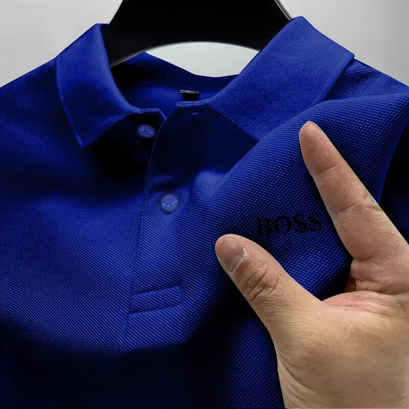 Blue polo shirt with 'BOSS' branding held by a hand on a gray background