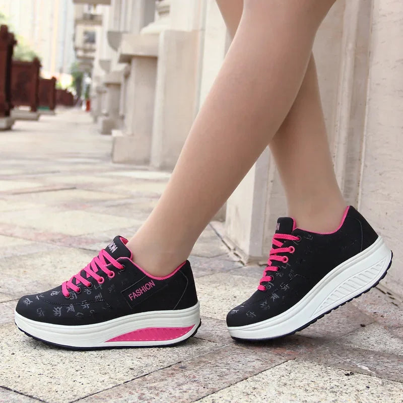 Black and pink sneakers worn on a stone pavement with a blurred background