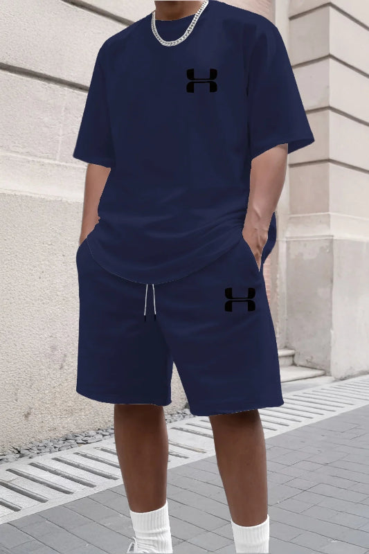 Person wearing navy Under Armour outfit standing against a stone wall.