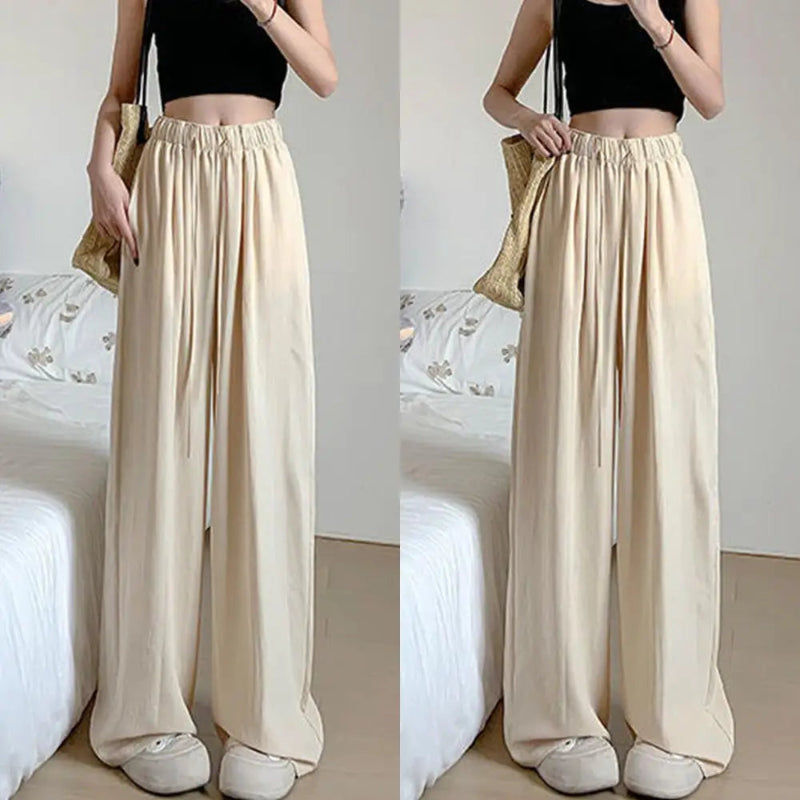 Beige wide-leg pants worn by a person on a neutral background