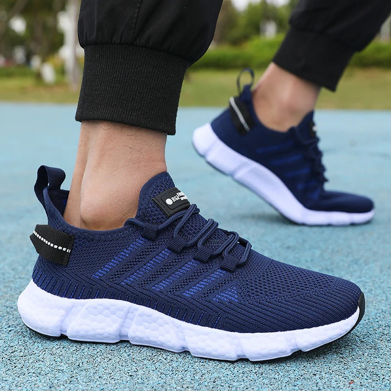Navy blue running shoes with white soles worn by a person on a blue surface.