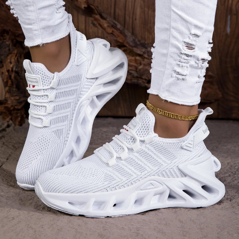 White sneakers worn with white ripped jeans on a neutral background