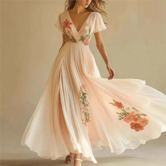 Woman wearing a flowing dress with floral embroidery on a plain background