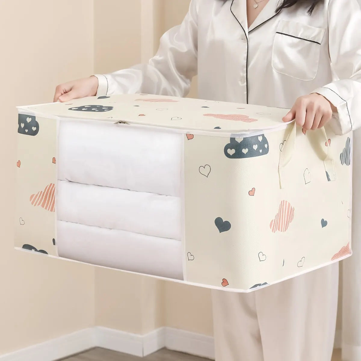 Person holding a large storage bag with cartoon designs against a neutral background