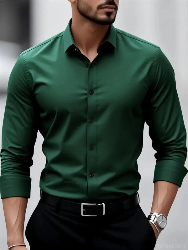 Man wearing a green dress shirt with black pants against a neutral background
