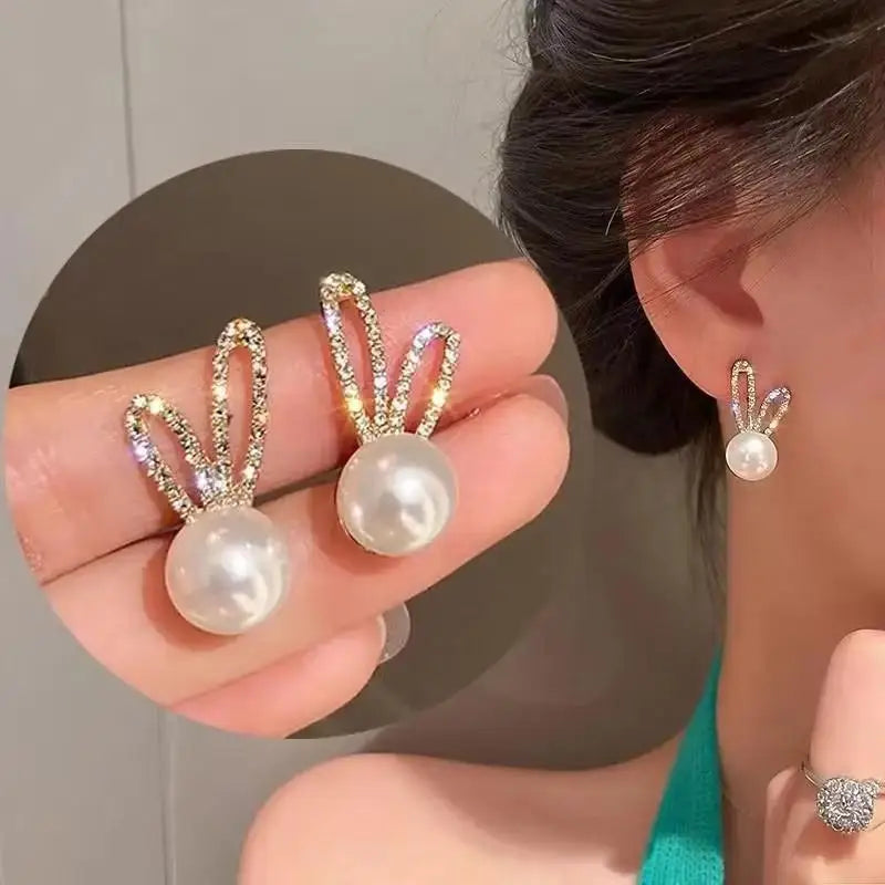 Pearl earrings being worn with a neutral background