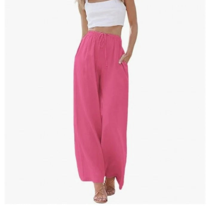 Person wearing bright pink wide-leg pants and a white top on a white background