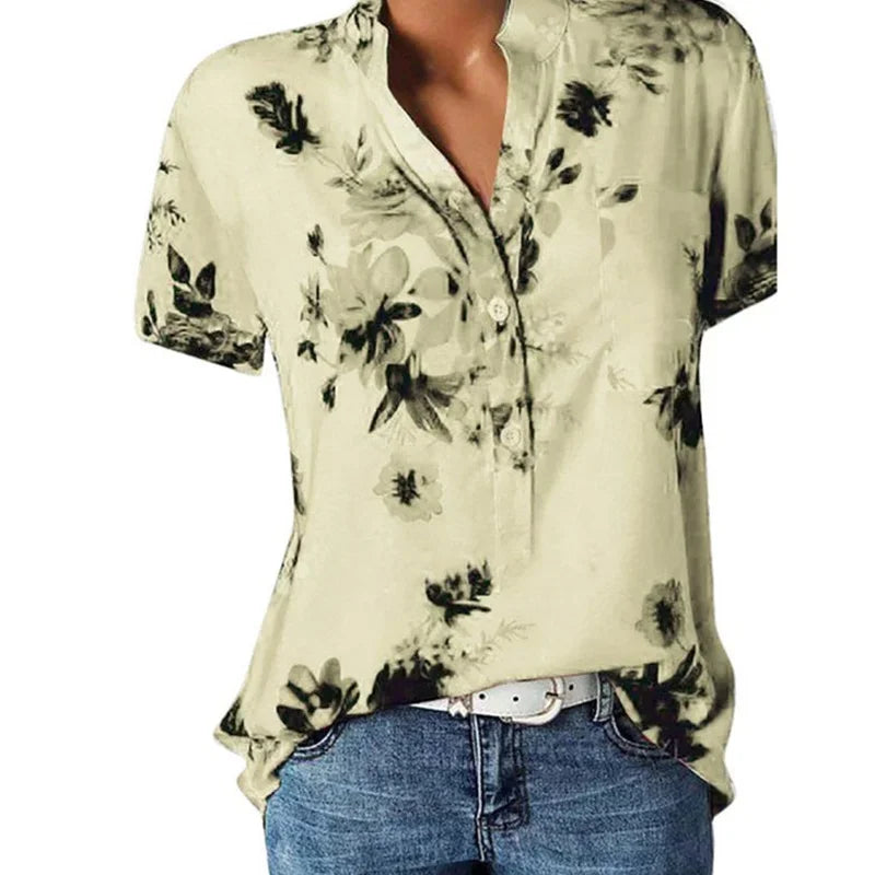 Beige floral blouse worn by a person on a white background