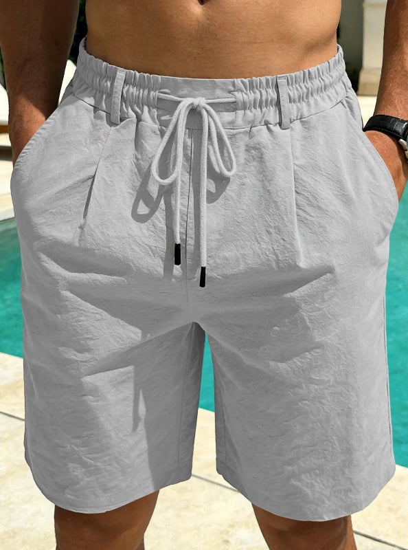 Person wearing gray shorts with a drawstring by a poolside
