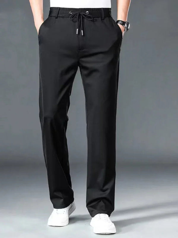 Black pants worn by a person on a gray background