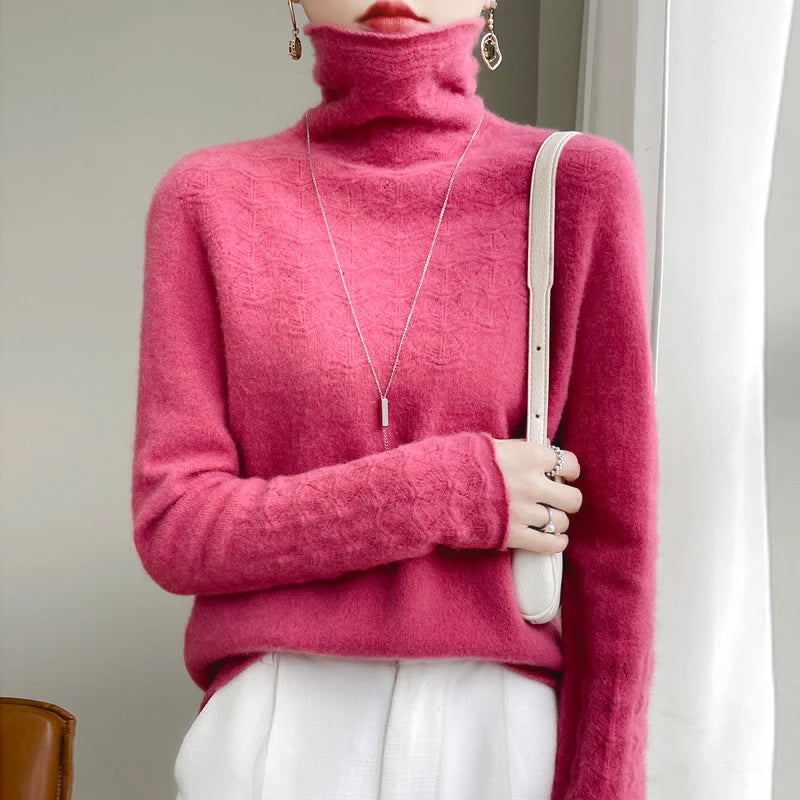Person wearing a bright pink turtleneck sweater holding a white bag indoors.