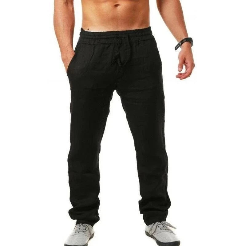 Black jogger pants worn by a person on a white background
