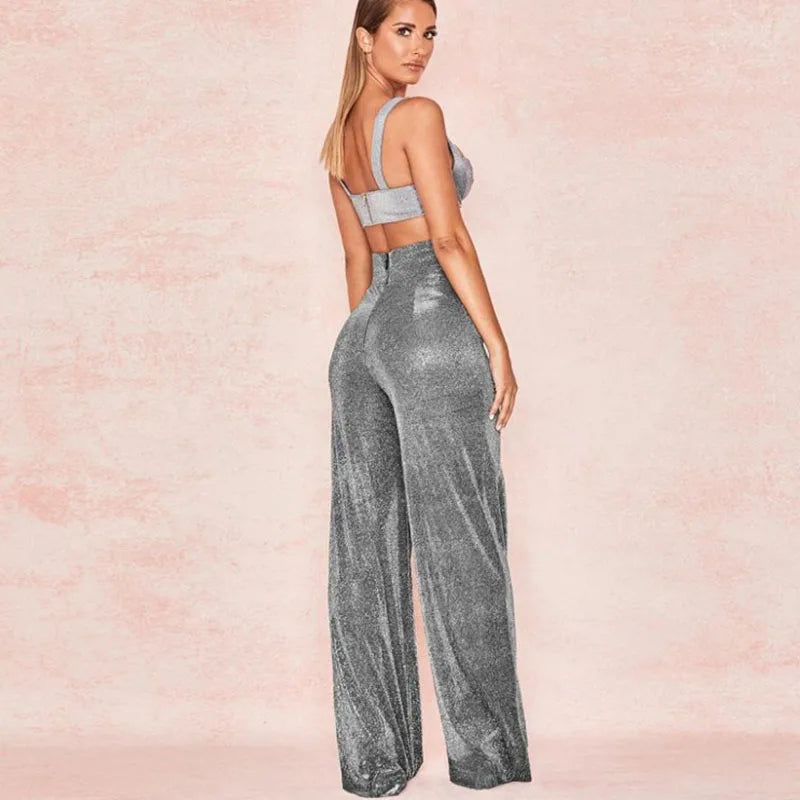 Woman wearing a sparkly silver jumpsuit on a pink background