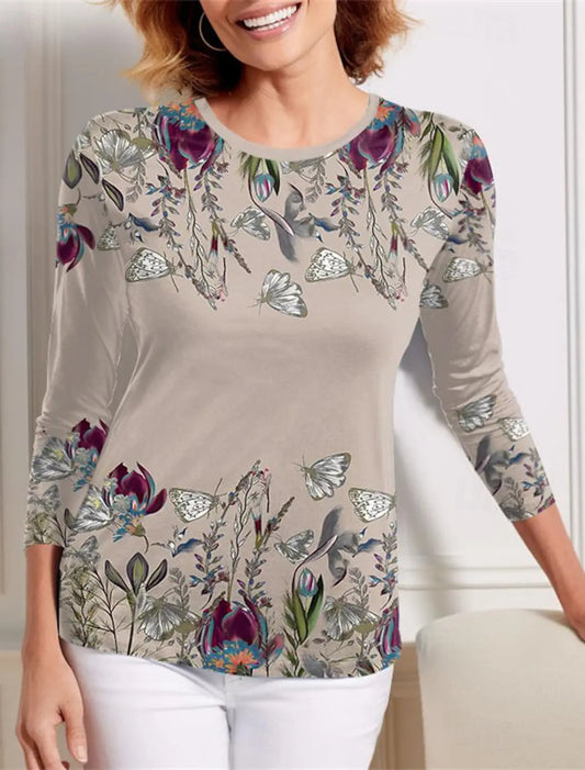 Woman wearing a floral and butterfly patterned top with a plain background