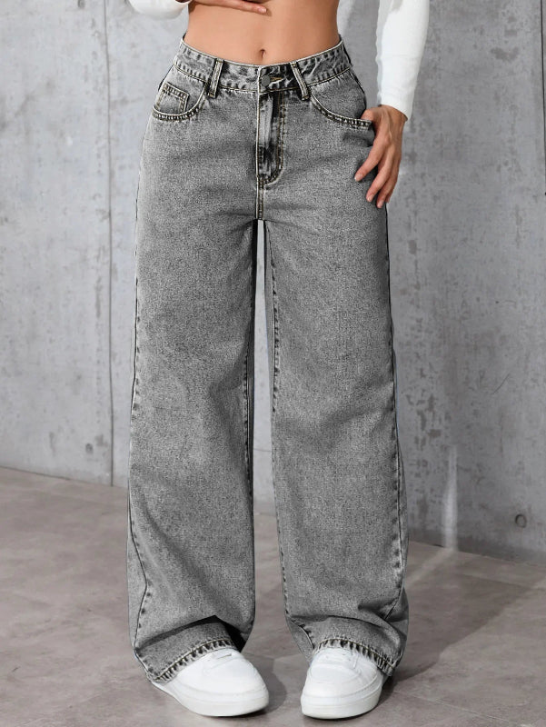 Person wearing wide-leg gray jeans with a plain background