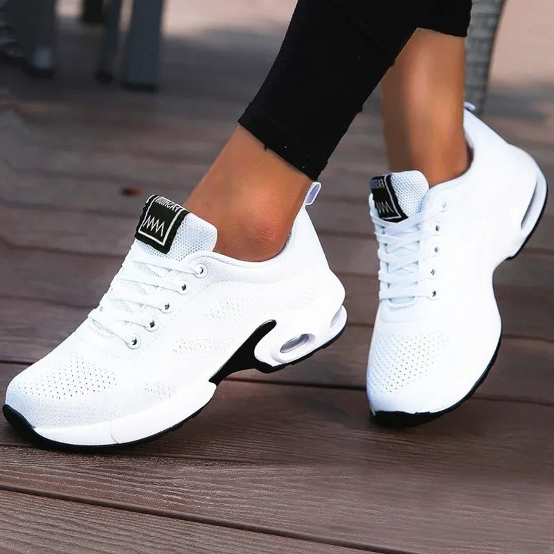 White sneakers with black accents on a wooden floor