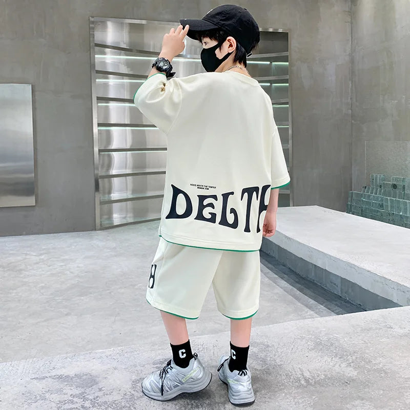 Person wearing a white oversized sweater with 'DELTA' printed on it, standing in a modern indoor setting.