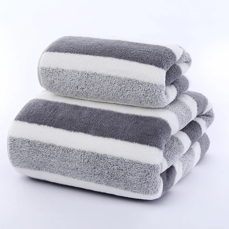 Stack of gray and white striped towels on a light gray background