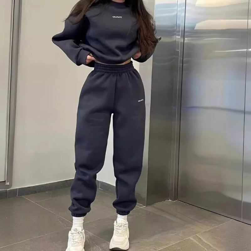 Person wearing a black outfit with white sneakers in an elevator.