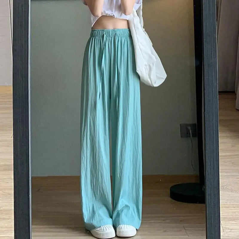 Person wearing light blue wide-leg pants standing in front of a mirror.