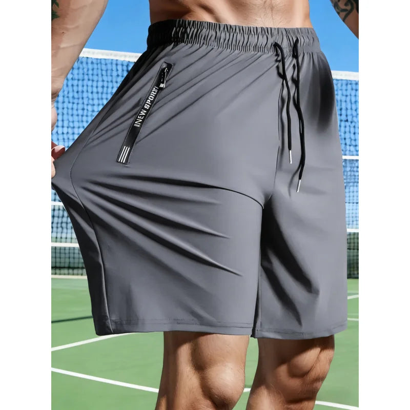 Gray athletic shorts with a zipper pocket on a tennis court background