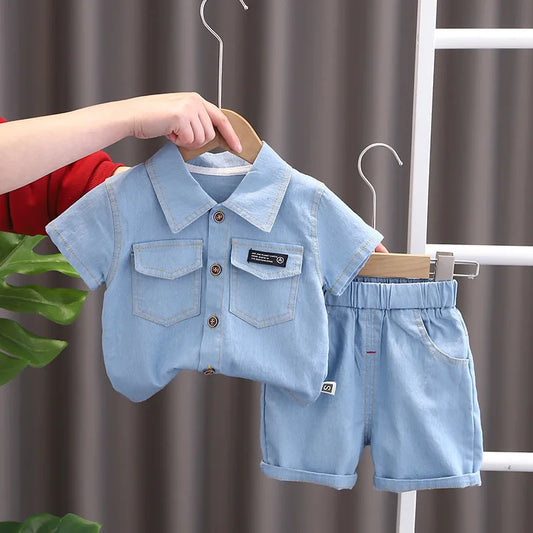 Children's denim shirt and shorts set on a hanger against a neutral background