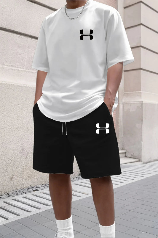 Person wearing a white Under Armour t-shirt and black shorts with the brand logo.